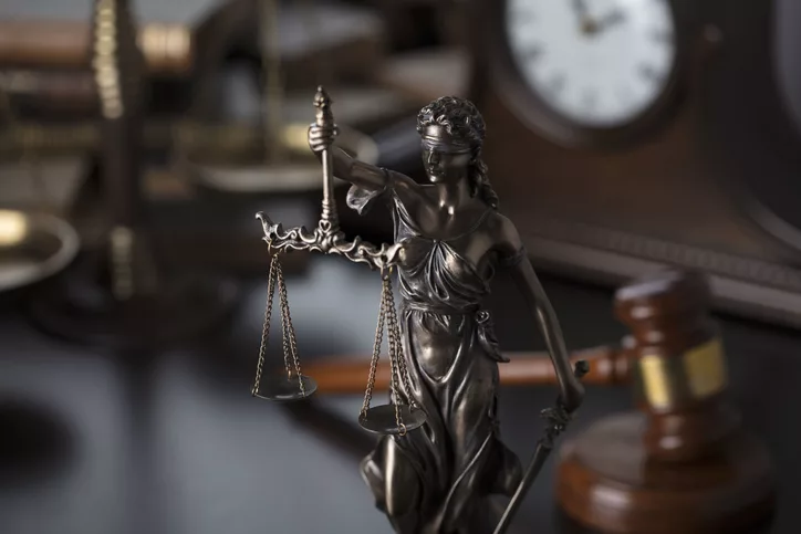 Judge’s gavel and Themis statue – symbols of law and justice.