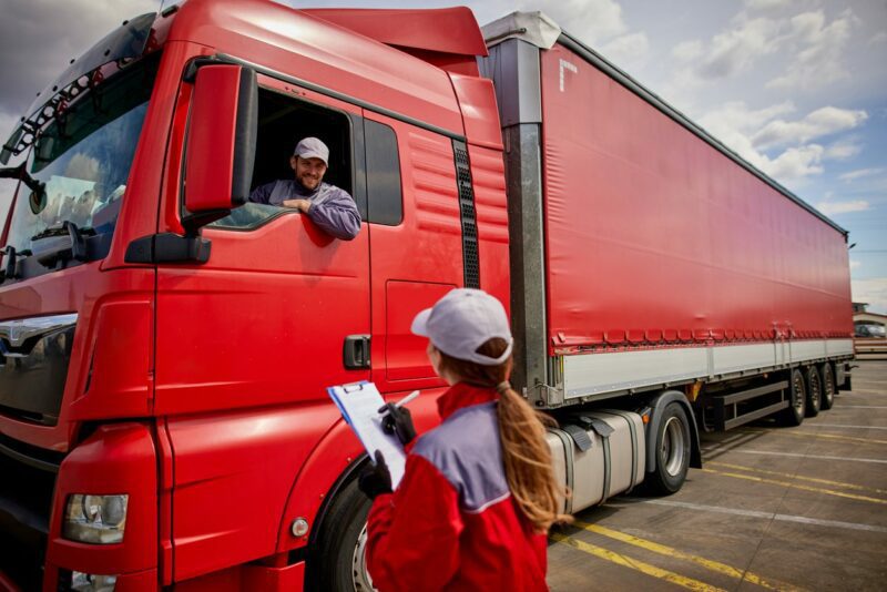 Truck driver and delivery person going through the shipping manifest